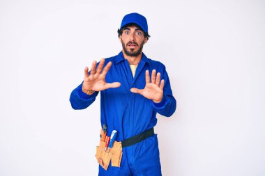 Kıvırcık saçlı ve ayı gibi giyinen yakışıklı genç adam korku ifadesinden korkmuş ve dehşete düşmüş. El hareketlerini bırak, şok içinde bağır. panik konsepti. 