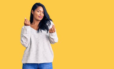 Uzun saçlı İspanyol kadın gündelik giysiler giyiyor. Elleriyle para hareketi yapıyor. Maaş ve milyonerlik işi istiyor. 