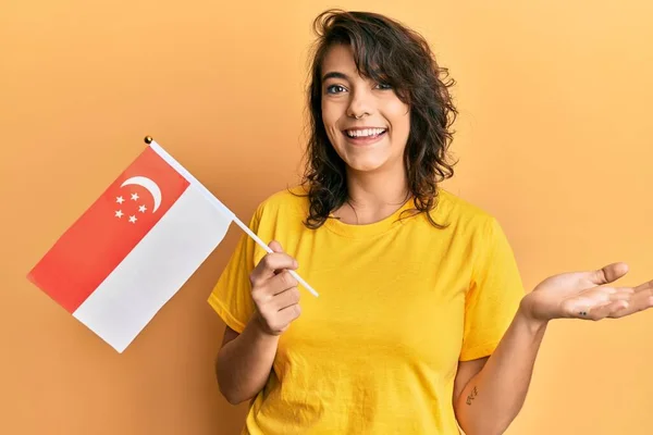 Joven Mujer Hispana Sosteniendo Bandera Singapurense Celebrando Logro Con Sonrisa —  Fotos de Stock