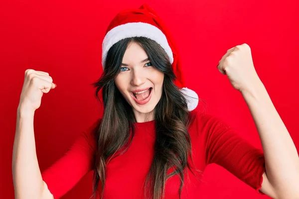 Νεαρή Όμορφη Καυκάσια Κοπέλα Φορώντας Χριστουγεννιάτικο Καπέλο Ουρλιάζοντας Υπερήφανη Γιορτάζει — Φωτογραφία Αρχείου