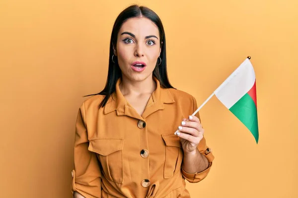 Jovem Morena Segurando Bandeira Madagascar Assustada Espantada Com Boca Aberta — Fotografia de Stock