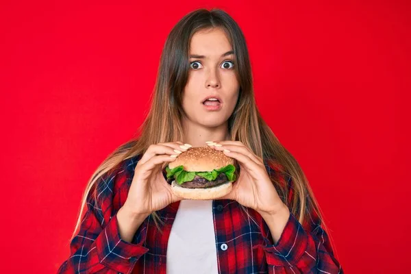 Bella Donna Caucasica Mangiare Gustoso Hamburger Classico Faccia Shock Cercando — Foto Stock