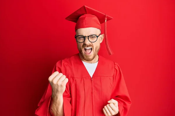 Young Redhead Man Wearing Red Graduation Cap Ceremony Robe Angry — Stock Photo, Image