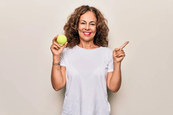 Schöne Sportlerin Mittleren Alters Hält Tennisball Über Isoliertem Weißem Hintergrund — Stockfoto