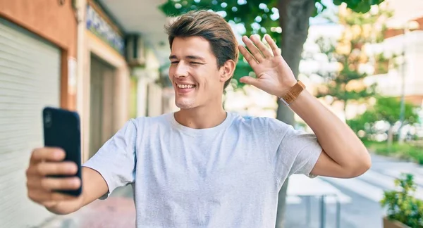 Jovem Caucasiano Sorrindo Feliz Fazendo Videochamada Usando Smartphone Cidade — Fotografia de Stock