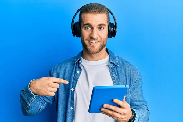 Νεαρός Καυκάσιος Άνδρας Που Χρησιμοποιεί Touchpad Φορώντας Ακουστικά Δείχνοντας Δάχτυλο — Φωτογραφία Αρχείου