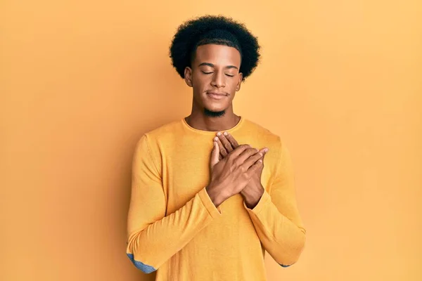 黑头发的非裔美国人穿着休闲装 双手放在胸前笑着 满脸感激地闭上眼睛 健康概念 — 图库照片