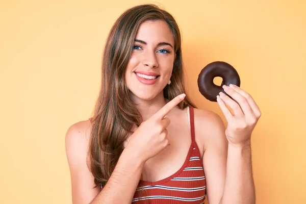 Güzel Genç Beyaz Bir Kadın Elinde Donut Tutarken Gülümsüyor — Stok fotoğraf
