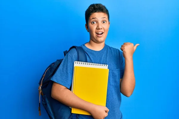 Adolescente Hispânico Menino Vestindo Escola Saco Segurando Livros Apontando Polegar — Fotografia de Stock