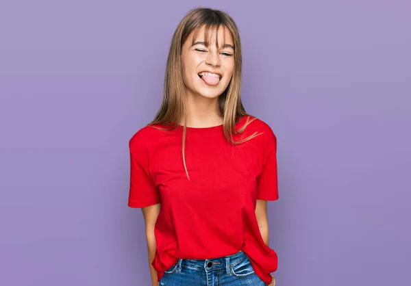 十代の白人の女の子は面白い表情で幸せ舌を突き出すカジュアルな赤いTシャツを着ています 感情の概念 — ストック写真