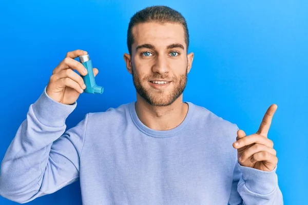 Joven Hombre Caucásico Sosteniendo Inhalador Asma Médica Sonriendo Feliz Señalando —  Fotos de Stock