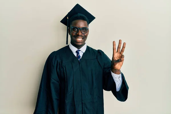 Przystojny Czarny Mężczyzna Czapce Dyplomowej Szacie Ceremonii Pokazując Wskazując Palcami — Zdjęcie stockowe