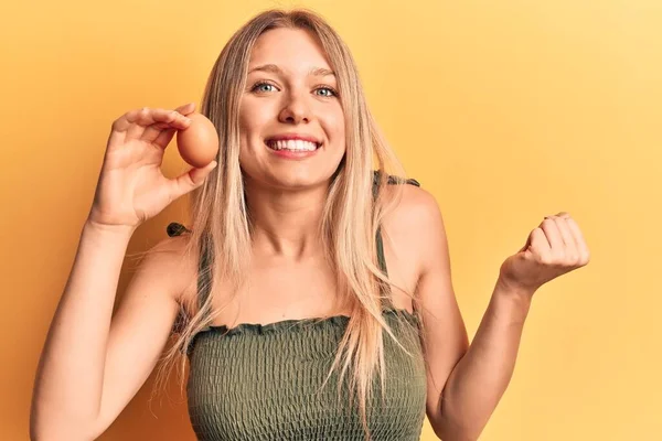 Yumurta Tutan Genç Sarışın Kadın Gururla Haykırıyor Zaferi Kutluyor Başarıyı — Stok fotoğraf