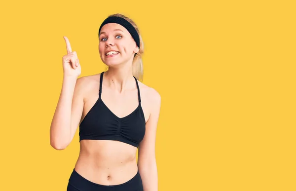 Spor Giyimli Güzel Sarışın Kadın Başarılı Bir Fikirle Işaret Ediyor — Stok fotoğraf