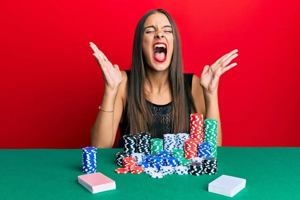 Jovem Hispânica Sentada Mesa Jogando Poker Celebrando Louco Louco Para — Fotografia de Stock