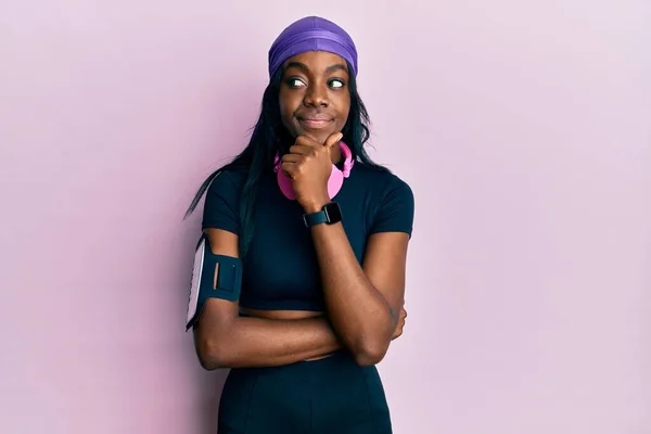 Mujer Afroamericana Joven Usando Ropa Gimnasio Usando Auriculares Con Mano —  Fotos de Stock