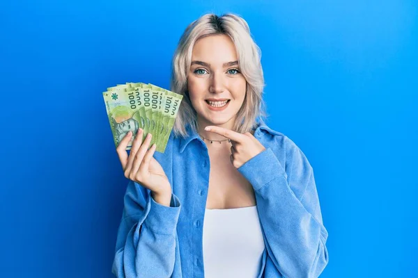 Mladá Blondýna Dívka Drží 1000 Chilských Pesos Úsměvem Šťastný Ukazující — Stock fotografie