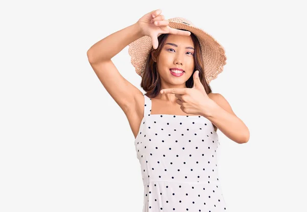 年轻美丽的中国姑娘戴着夏帽 笑容满面 手指手画脚 创意与摄影概念 — 图库照片