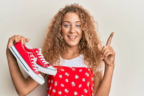 Hermosa Chica Adolescente Caucásica Sosteniendo Zapatos Casuales Rojos Sonriendo Con —  Fotos de Stock