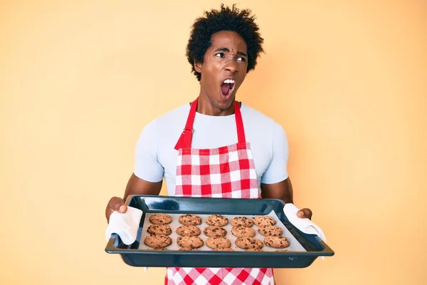 Нахабний Афро Американець Волоссям Формі Пекарні Тримає Домашнє Печиво Сердитим — стокове фото