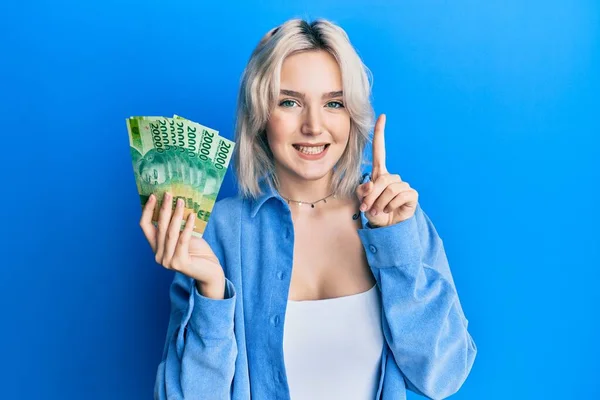 Ung Blond Flicka Som Håller Indonesiska Rupiah Sedlar Ler Med — Stockfoto