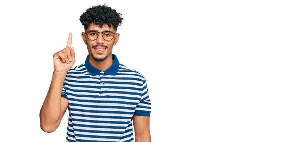 年轻的阿拉伯男子身穿休闲装 戴着眼镜 带着第一指尖 面带微笑 自信而快乐 — 图库照片