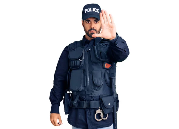 若いヒスパニック系の男は手の手のひらで歌うのを停止する警察の制服を着ている 顔に負の重大なジェスチャーで — ストック写真