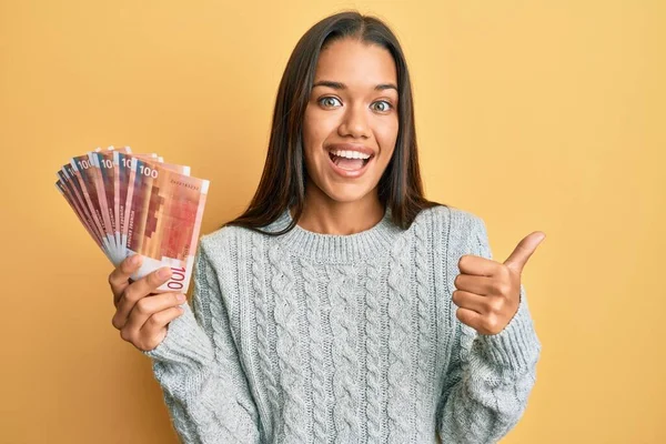 Beautiful Hispanic Woman Holding 100 Norwegian Krone Banknotes Pointing Thumb — Stock Photo, Image