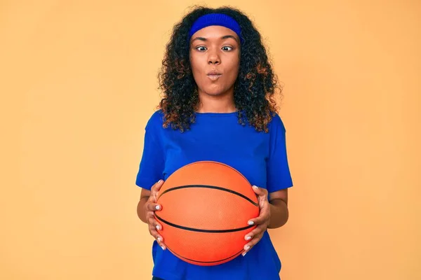 Jovem Afro Americana Segurando Bola Basquete Fazendo Cara Peixe Com — Fotografia de Stock