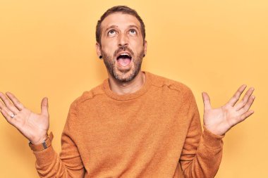 Genç, yakışıklı, sıradan kıyafetler giyen çılgın ve deli gibi bağıran agresif bir ifade ve kollarla bağıran bir adam. hüsran kavramı. 