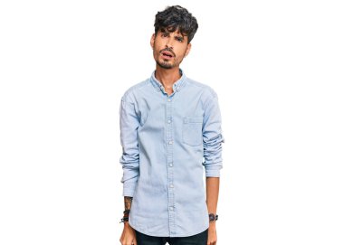 Şok olmuş gibi giyinen genç İspanyol adam şüpheci ve alaycı görünüyor, ağzı açık kalınca şaşırıyor. 