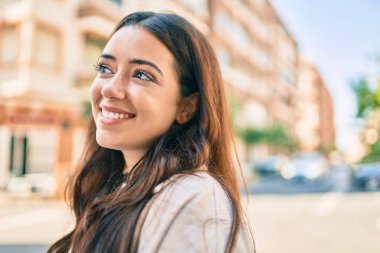 Genç İspanyol kadın gülümseyerek şehirde mutlu mesut yürüyor..