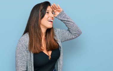 Güzel İspanyol kadın gündelik giysiler giyiyor çok mutlu ve gülümsüyor başlarını kaldırıp uzaklara bakıyor. arama kavramı. 