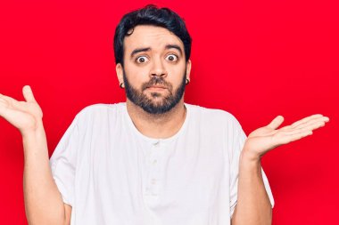 Gündelik kıyafetler giyen genç İspanyol adam habersiz ve kolları açık, hiçbir fikri ve şüpheli bir yüzü var.. 