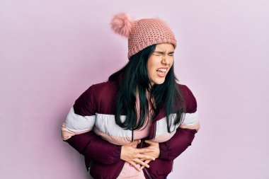 Mide bulantısı, acı verici bir hastalık yüzünden yün kazak ve el üstünde kep giyen genç İspanyol kadın. Ağrı kavramı. 