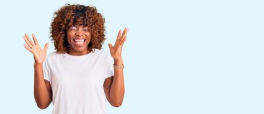 Sıradan beyaz tişörtler giyen genç Afro-Amerikalı kadın, başarı için çılgın ve çılgın kutlamalar yapıyor. Kolları havada ve gözleri kapalı, heyecanlı çığlıklar atıyorlar. Kazanan konsept 