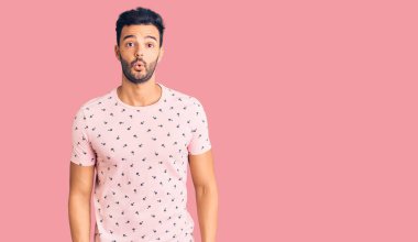 Genç, yakışıklı, sıradan kıyafetler giyen, ağzı açık, korkmuş ve şaşırmış bir adam. 