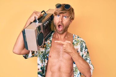 Yaz tarzı giyinen genç sarışın adam şok olmuş suratına kaset çalar tutuyor. Şüpheci ve alaycı görünüyor. Ağzını açtığında şaşırıyor. 