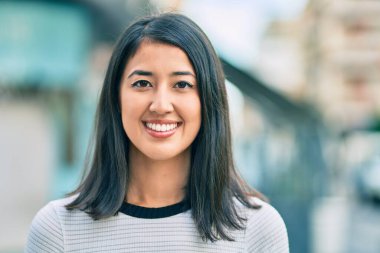 Genç İspanyol kadın gülümseyerek şehirde mutlu mesut yürüyor..