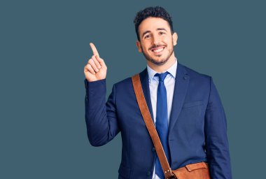 İspanyol takım elbiseli ve deri çantalı genç adam bir fikir ya da soru işareti ile şaşırdı. 