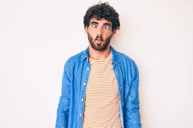 Kıvırcık saçlı yakışıklı genç adam ve sıradan kot ceket giyen ayı dudaklı balık suratı yapan çılgın ve komik bir jest. Komik ifade. 