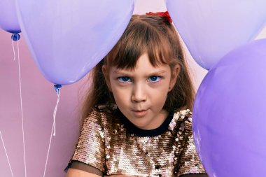 Kafkasyalı küçük kız balon tutuyor şüpheci ve gergin, sorun yüzünden surat asıyor. negatif kişi. 
