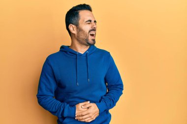 Mide bulantısı, acı verici bir hastalık yüzünden günlük giysiler giyen genç İspanyol bir adam. Ağrı kavramı. 