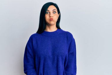 Gündelik kıyafetler giyen, komik yüzlü, yanak şişiren beyaz bir kadın. Havayla şişmiş ağız, çılgın bir ifade.. 