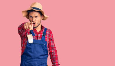 Yakışıklı Latin Amerikalı, tamirci üniforması giyen genç adam kameraya kızgın ve sinirli bir şekilde seni işaret ediyor. 