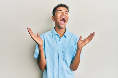 Genç, yakışıklı, Afro-Amerikalı sıradan kıyafetler giyen, çılgın ve çılgın başarısını kutlayan, kollarını kaldırmış, gözlerini kapatmış heyecanlı çığlıklar atan bir adam. Kazanan konsept 