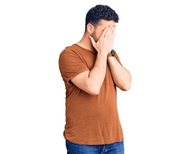 Ağlarken suratını ellerle kapatan, günlük kıyafetler giyen genç İspanyol. depresyon kavramı. 