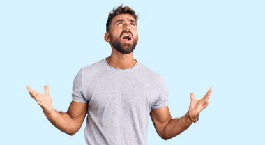 Gündelik kıyafetler giyen genç İspanyol adam deli gibi bağırıyor ve agresif bir ifade ve kollarla bağırıyor. hüsran kavramı. 