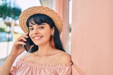 Yaz stili giyinmiş genç İspanyol turist kız şehirde akıllı telefondan konuşuyor..