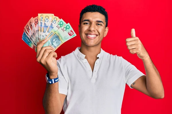 Hombre Árabe Joven Sosteniendo Dólares Australianos Sonriendo Feliz Positivo Pulgar —  Fotos de Stock